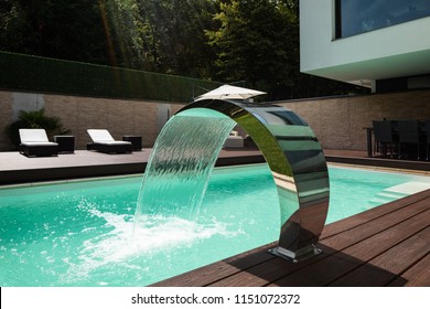Detail of swimming pool with fountain in modern villa. Nobody inside