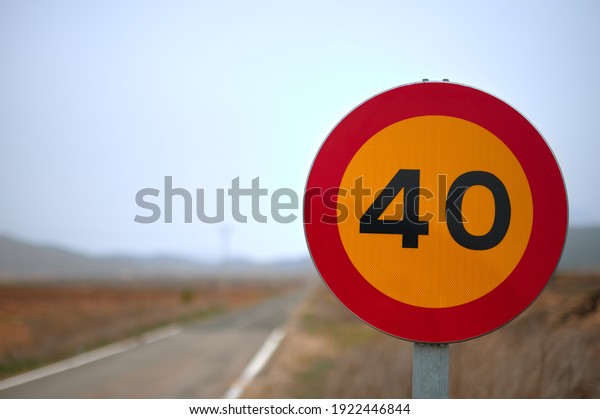 detail of a temporary traffic sign\
prohibiting traffic over 40 kmh with a road in the\
background