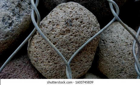 Detail of the texture of the rocks inside the iron wire with a hollow surface - Powered by Shutterstock