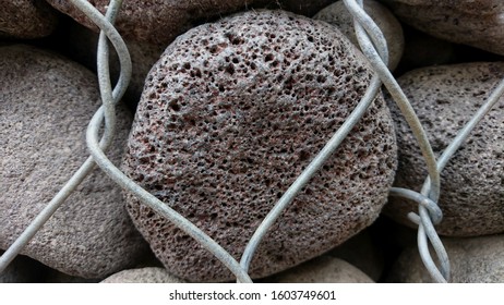 Detail of the texture of the rocks inside the iron wire with a hollow surface - Powered by Shutterstock