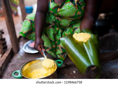 Detail Of Traditional African Corn Foufou On Plantain Leaf Held By Black Woman Cooking In Humble Home Kitchen 