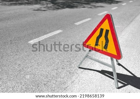 detail of a traffic sign indicating the narrowing of the road due to construction work