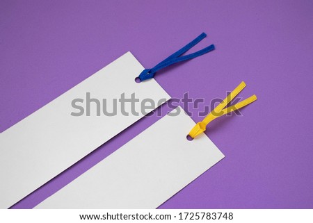 Detail of two paper bookmarks on a purple background