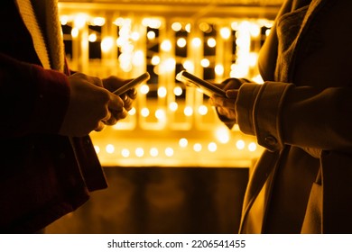 Detail of two persons holding smartphones - Shutterstock ID 2206541455