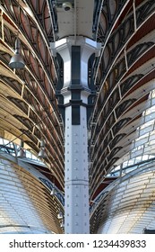 Detail of a Victorian metal column and parts of the glazed roof on wrought iron arches of Paddington Station in London.