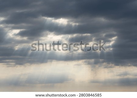 Detail view of a cloudscape with sun's rays piercing through storm clouds