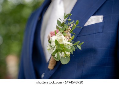 Detail view from of groom with floral ornament on a three-piece groomsuit - Powered by Shutterstock