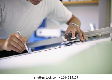 Detail View Of Man Working On A Drafting Table