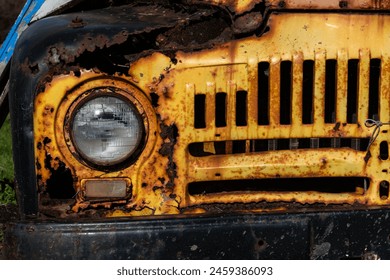 Detail view of a rusted, old, decommissioned vintage, yellow, pickup truck parked in a field of grass.  - Powered by Shutterstock