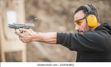 Detail View Of Shooter Holding Gun And Training Tactical Shooting, Close Up. Shooting Range