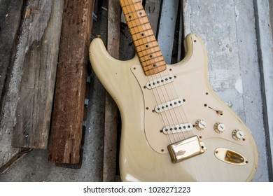 detail of vintage electric guitar body against wooden background.