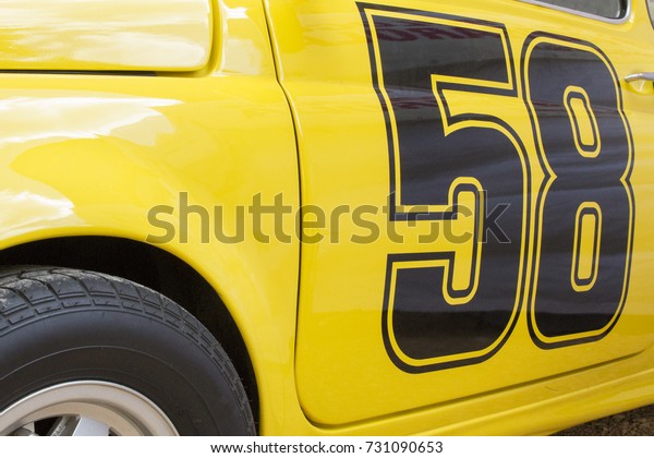 Detail of a vintage\
yellow car car. The car will run the race with the number 58\
printed on the door.\
