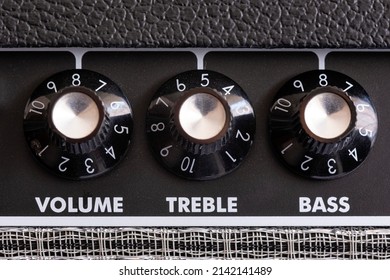 detail of the volume, treble and bass control knobs of a guitar amplifier, equalization dials close up, selective focus horizontal