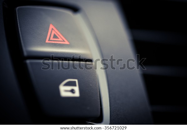 Detail of a warning button\
in a car.