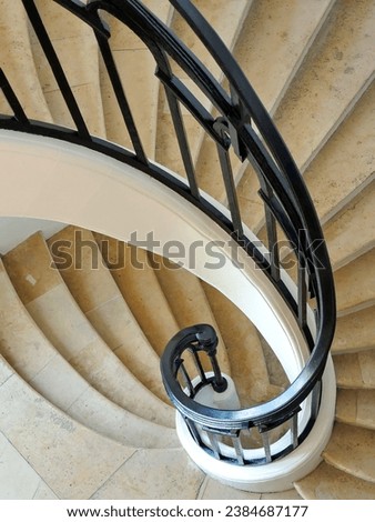 Detail of white curved staircase with wrought iron railings