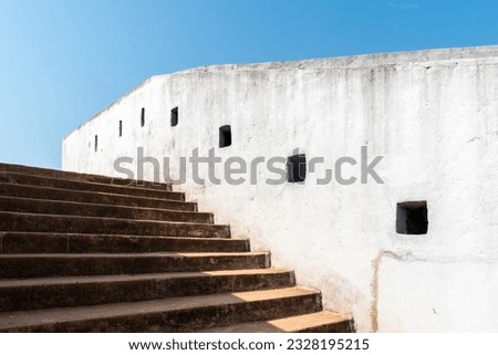 Detail of the white walls and steps leading up to the ancient watch tower with arrowslits and loopholes built by Tipu Sultan.