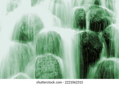 Detail of a wild waterfall on a green background with rocks. Water running down the rocks in a smooth flow. harmony, balance in natural green world. - Powered by Shutterstock