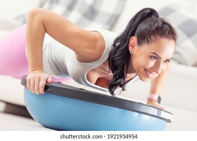 Detail Of A Woman Doing Pushups On A Blue Balance Ball During A Home Workout.