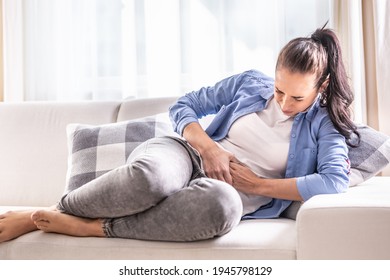 Detail of a woman in pain of abdominals, gallbladder, ovaries, appendix, liver or intestines holding belly with hands. - Shutterstock ID 1945798129