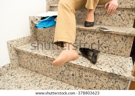 detail of woman with stilettos falling down with shopping bags on stairs 