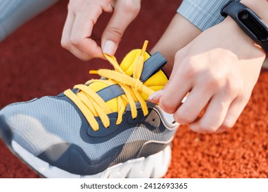 Detail of woman tying shoelace on basketball court getting ready for morning exercise routine - Powered by Shutterstock