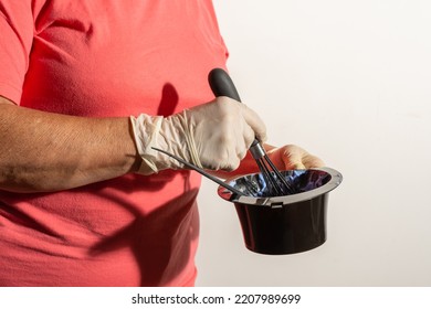 Detail Of A Woman's Hand With A Latex Glove Mixing Chemicals To Dye Hair Isolated In White Background