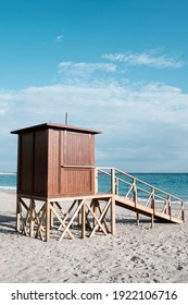 Detail Of A Wooden Lifeguard Tower In A Lonely Beach Close To The Seashore, With The Ocean In The Background