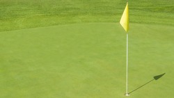 Detail Of The Yellow Flag And The Final Hole Of A Golf Course At A Sports Center In Rome, Italy. The Grass Has A Lively Green Color And The Playground Is Well Maintained.