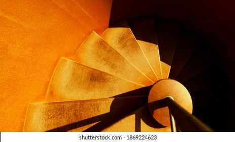 detail of yellow spiral steel staircase. modern spiral staircase steps seen from above. Golden downward spiral. Descending. Yellow and dark texture background.