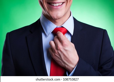 detail of a young business man in a suit and tie on green background