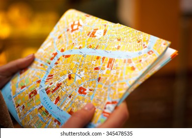 Detail of young tourist hands holds city map to trying navigate using map in Venice city maze on her holidays - Powered by Shutterstock