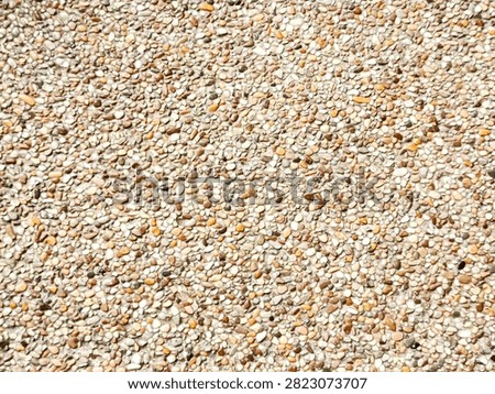 Detailed background texture of smooth small river pebbles in concrete