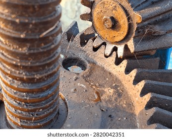 Detailed close up of interlocking rusty metal spur gears and threaded shaft mechanism