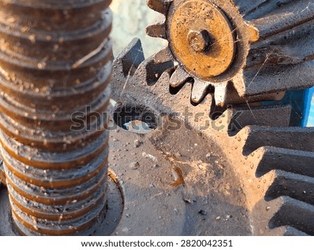 Detailed close up of interlocking rusty metal spur gears and threaded shaft mechanism