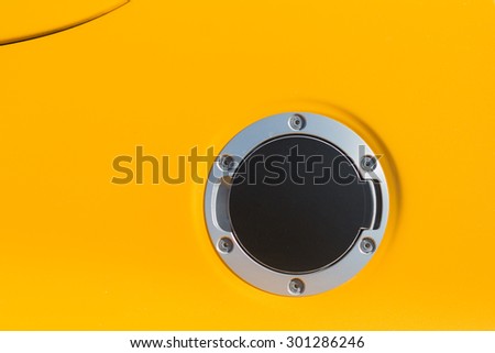 Detailed close up of a petrol cap cover on a modern yellow car.