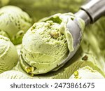 A detailed close up view showcasing a scoop of green pistachio ice cream