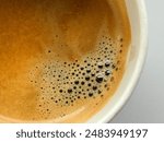 Detailed close-up of a freshly brewed espresso, showcasing the rich, golden crema on top