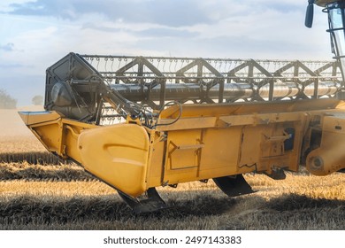 Detailed Close-Up of Harvesting Machine in Action During Late Afternoon in Grain Field - Powered by Shutterstock