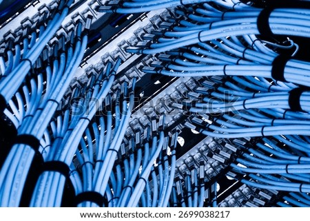 A detailed close-up image showcasing a complex arrangement of gray electrical wires and cables, emphasizing the intricacies of modern networking and technology.