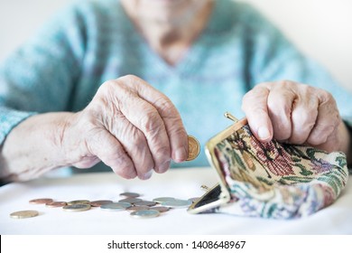 Detailed closeup photo of elderly 96 years old womans hands counting remaining coins from pension in her wallet after paying bills. Unsustainability of social transfers and pension system.