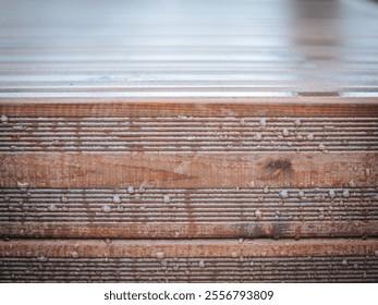 A detailed close-up of a wooden surface covered with frost and water droplets, showcasing natural textures and a blurred background for copy space. - Powered by Shutterstock