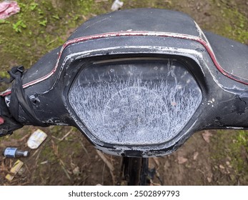 A detailed close-up of a worn and weathered motorcycle dashboard, showcasing signs of aging and usage. The faded speedometer and cracked plastic add a vintage and rustic feel to the image, making it p - Powered by Shutterstock