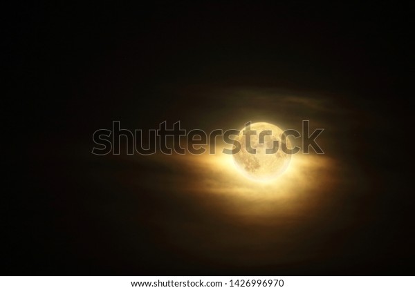 Detailed full\
moon in dark atmospheric cloudy\
sky