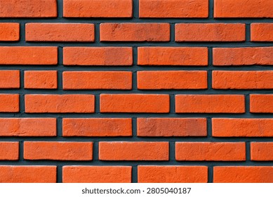 A detailed, high-resolution image showcasing the texture of a red brick wall, highlighting the individual bricks and the dark grout between them.