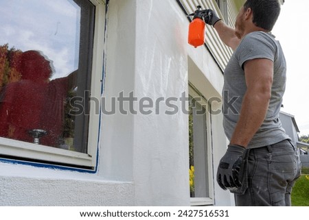 Detailed Image Capturing Man's Final Preparatory Steps, Moistening Wall Surface for Putty Application.
