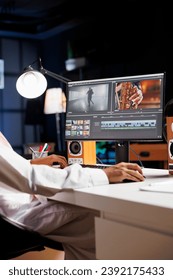 Detailed image of a creative male individual editing a movie on his desktop computer. Selective focus on the pc monitor displaying the work of a freelance videographer, filmmaker.