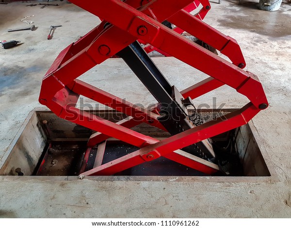 Detailed image of ,  hydraulic car lift at the\
mechanics little workshop,\
garage.