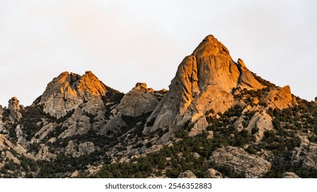 A detailed image of majestic mountain ranges with peaks and valleys covered in lush greenery and scattered forests. The scene features rocky cliffs and rolling hills, with mist clinging to valleys. - Powered by Shutterstock