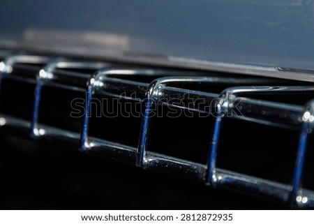 Detailed macro image of a chrome wire rack with reflective metallic surface and soft blurred background. Ideal for industrial, storage, organization, and abstract texture themes