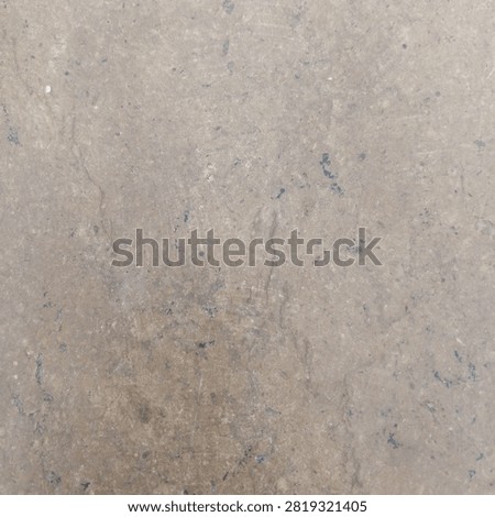 Detailed macro texture of a smooth flat brown stone surface showing subtle scratches tiny black specks and natural flaws
